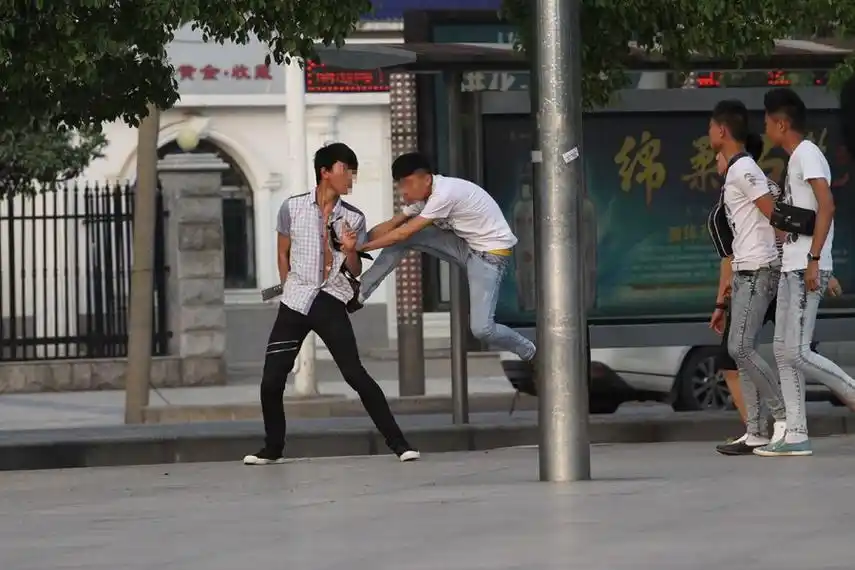 组图湖北襄阳中学生街头打架多人围殴一人有人拿砍刀挥舞