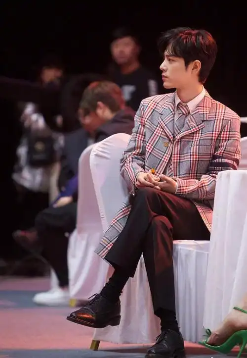 肖战身穿灰色开衫毛衣坐在那温柔帅气而格纹西装造型深情温柔