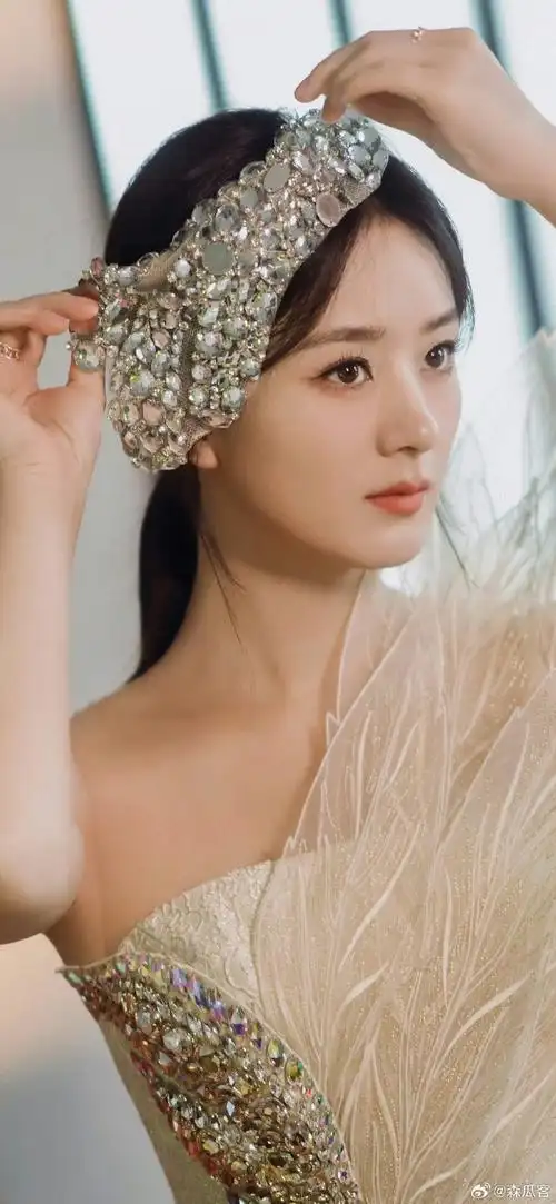 她的发型也很独特,头发扎成高高的发髻,露出美丽的后