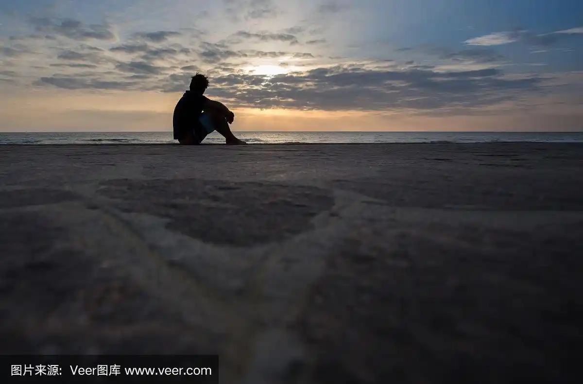 一个男人的剪影坐在夕阳下