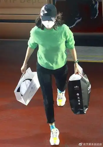 机场街拍章子怡绿色针织衫黑色牛仔裤活泼美丽