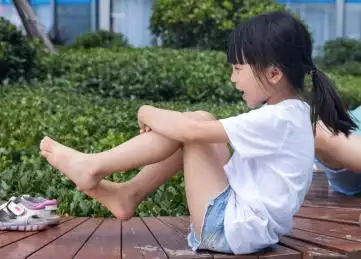 坐在户外椅子上玩耍的小女孩