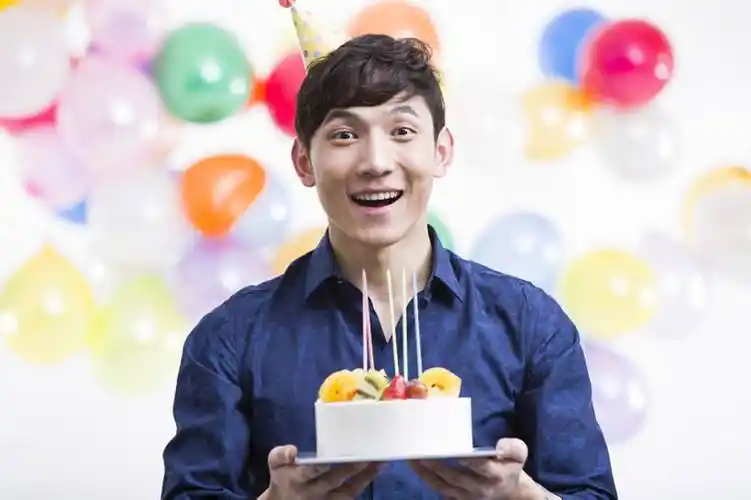 手拿生日蛋糕的年轻男子