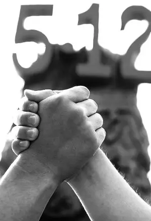 牵手传力量    5月12日,两名市民在长春市文化广场纪念活动中双手