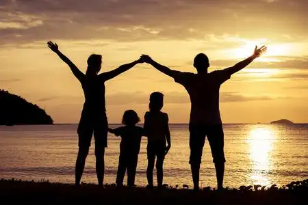 幸福的家庭的剪影在一元在沙滩上玩的人照片