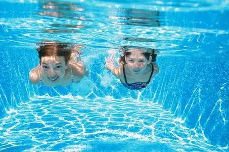 孩子们健身和运动活跃家庭度假的游泳池里游泳照片