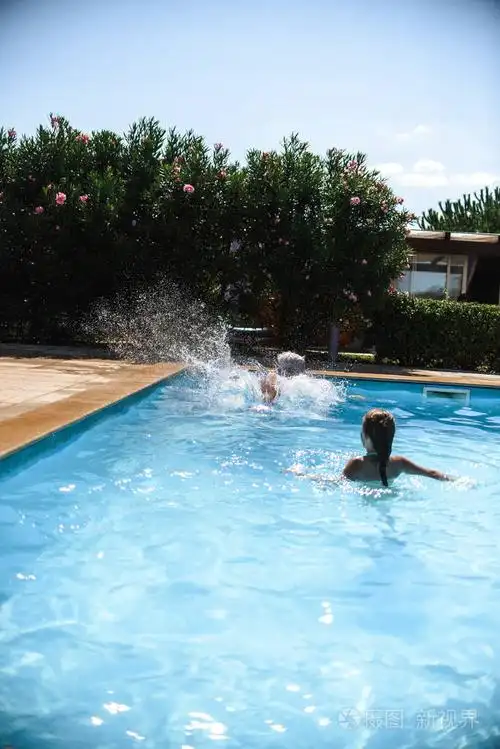 可爱的小女孩在游泳池里玩暑假