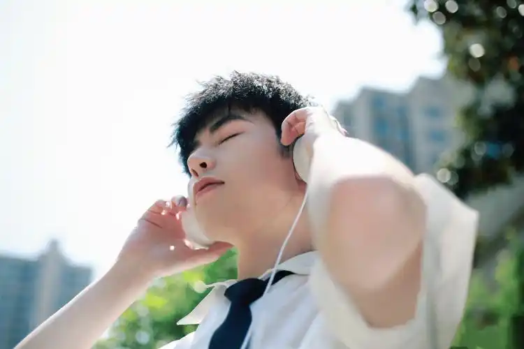 阳光下享受音乐的帅哥写真图片