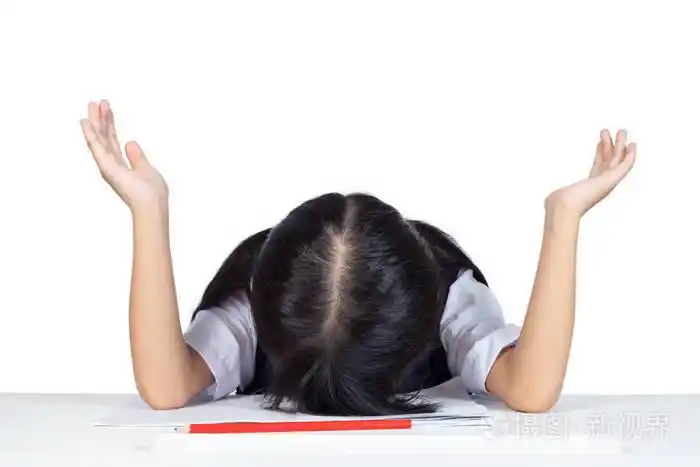 亚洲华人小女孩在学校制服睡在桌子上孤立的白色背景