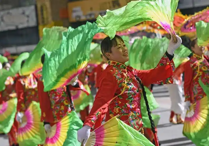 2月10日,社火队伍在街头表演扭秧歌.