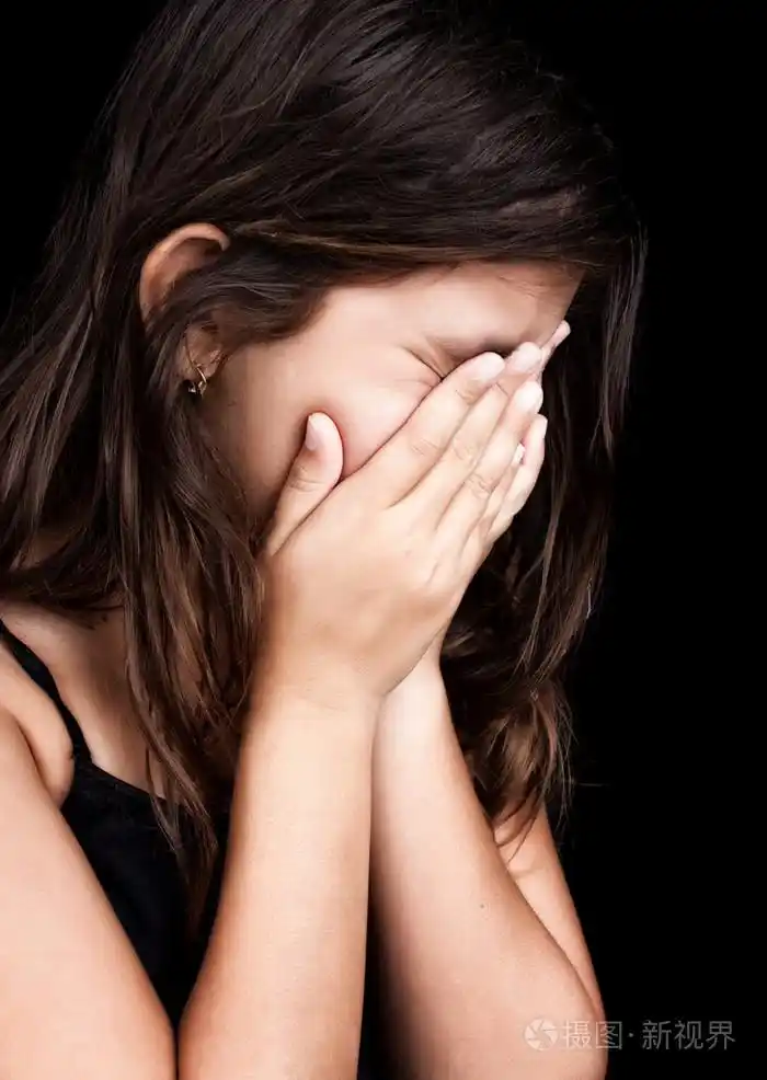 美丽的女孩哭和覆盖她的脸