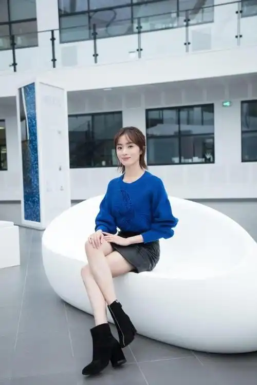 照片中胡冰卿身穿印花外套,下身搭配黑色小短裙,脚上搭配了一双黑色的