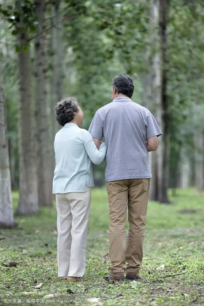 在公园散步的恩爱老夫妻