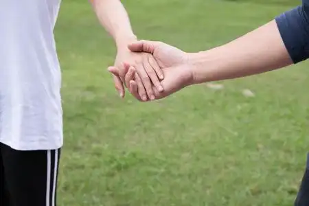 快乐的年轻夫妇手牵手在花园里.男朋友和 girlfr照片