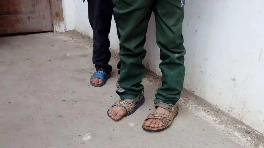 已是寒冷的冬天,但是陈佳俊兄弟还穿着凉鞋,仔细一看还是两只不同的