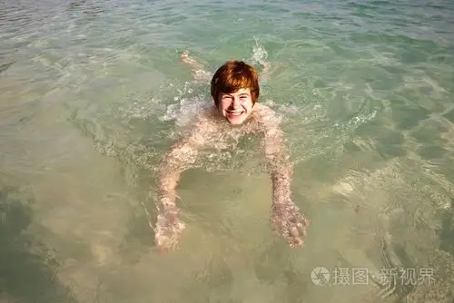 在美丽清澈的海洋里游泳的男孩