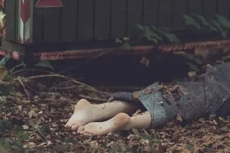 腿被放在停尸房的白色戴着黑手套的病理学家在脚上挂着空白的白色标签