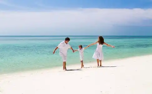 海边孩子跳舞一家三口在一个热带的海滩上跳舞照片