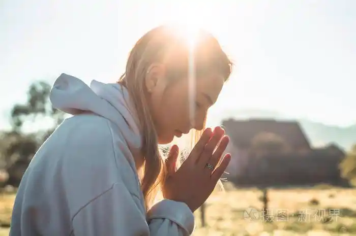 在清晨的女孩闭上眼睛在户外祈祷双手折叠在祈祷概念的信仰灵性宗教