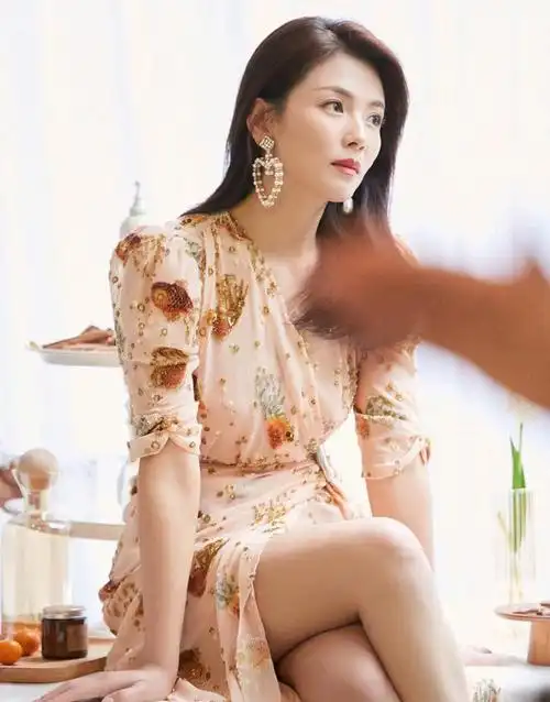 刘涛穿着一件绿色衣裳,搭配黑色短裙的写真照片中,故意展示了她修长