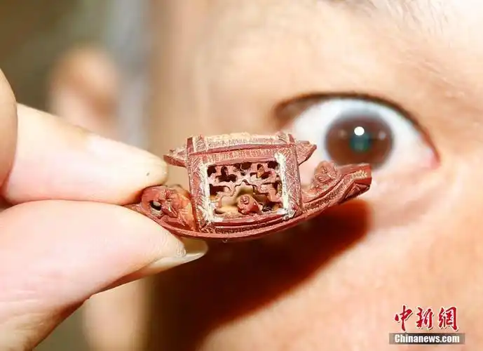 台北微雕艺术家在橄榄核上写诗雕刻