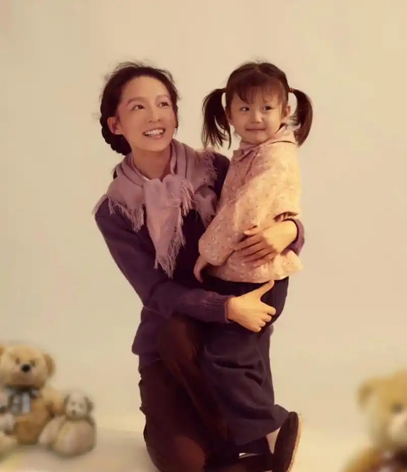 李沁和剧中的女儿合影,抱着孩子一脸和善笑容,一看就是好性格的姑娘