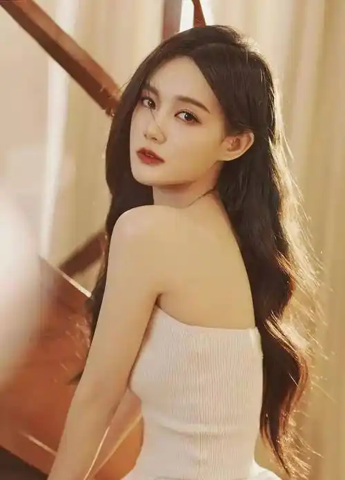 明星写真:李一桐身穿白色抹胸连衣裙,大波浪发,高跟鞋的时尚艺术照