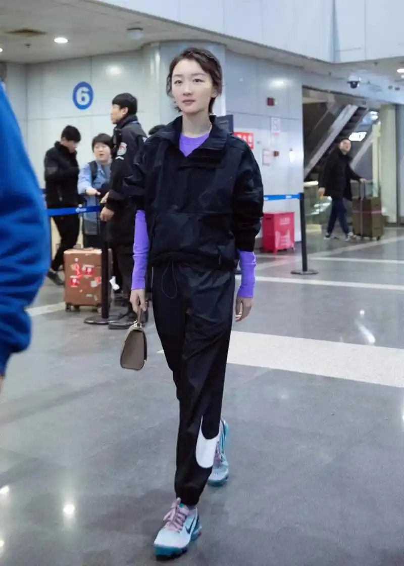 周冬雨黑色工装现身机场紫色内搭明亮个性