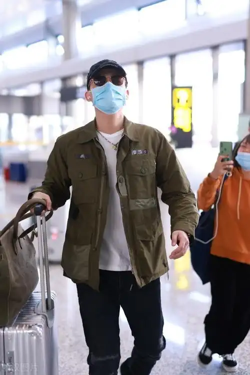 欧豪身穿军绿色外套仿佛特种兵,独自拎大包小裹赶行程