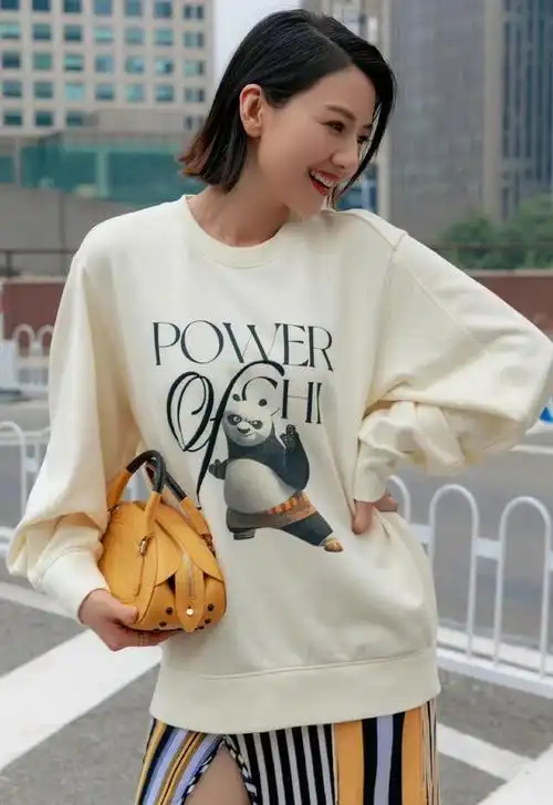 高圆圆用白色的圆领卫衣配上创意的拼色开叉半身长裙,在搭配一件