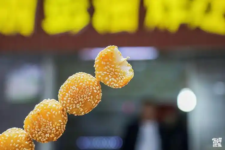 炸至金黄的芝麻球外壳焦脆,内里软糯,表面裹的芝麻颗粒也越嚼越香.
