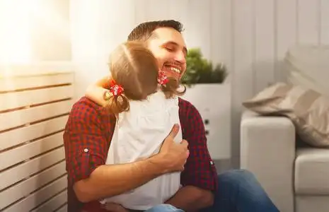 快乐家庭的女儿,在 holida 上拥抱着爸爸和笑照片