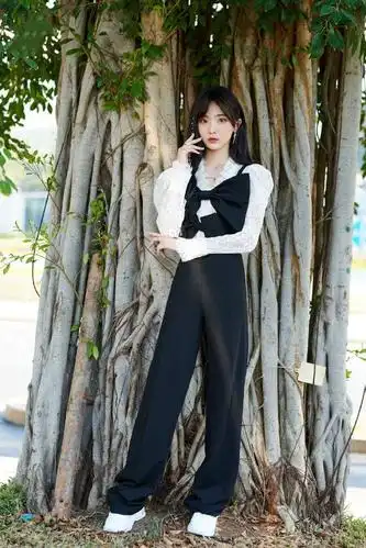 她穿着黑色西装裤超显腿长,再配上画龙点睛的发饰,戴着心形的眼镜也