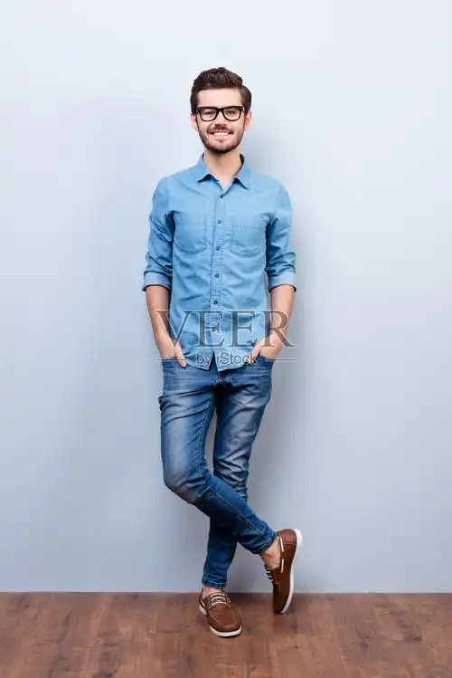 头发的年轻人在休闲时尚的穿着他看着舷梯背景上的摄像机照片摄影图片