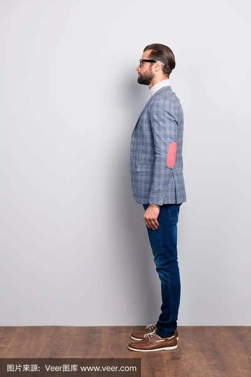 全身侧视图肖像聪明的绅士在高领,格子夹克,眼镜站在灰色的背景