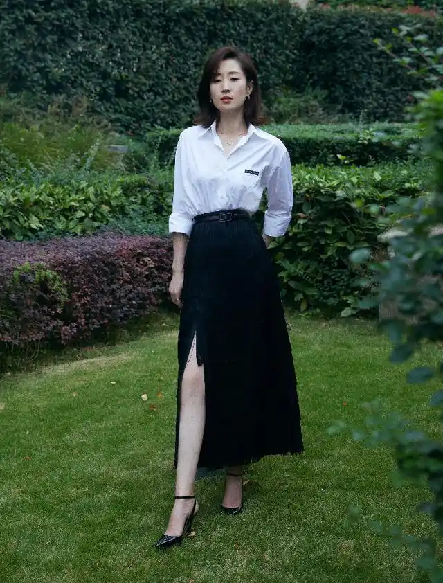 刘敏涛最新造型白色衬衫搭配流苏半身裙,漫步小径间流露成熟魅力