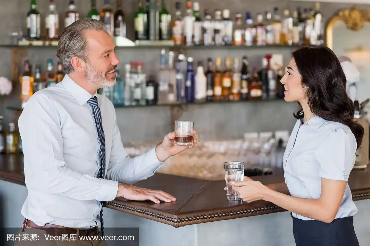 商人和女人站在吧台边喝酒