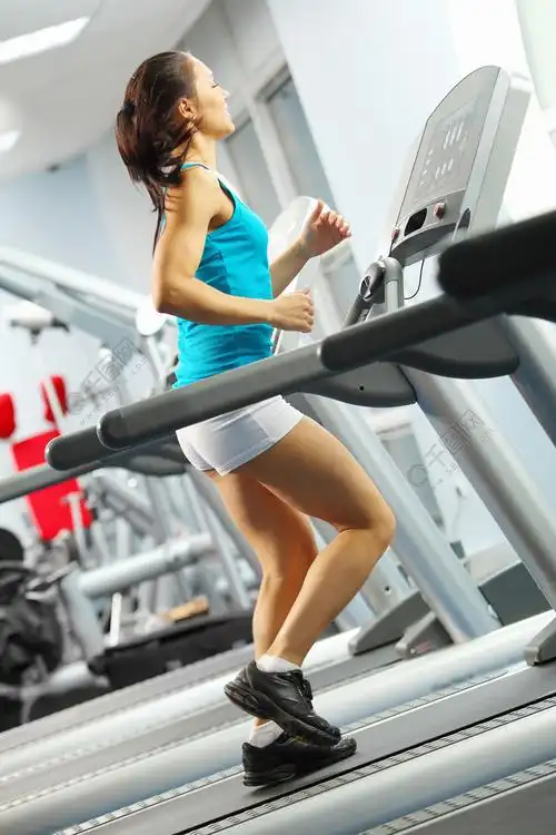 有氧运动在跑步机上运行的健身女孩的形象