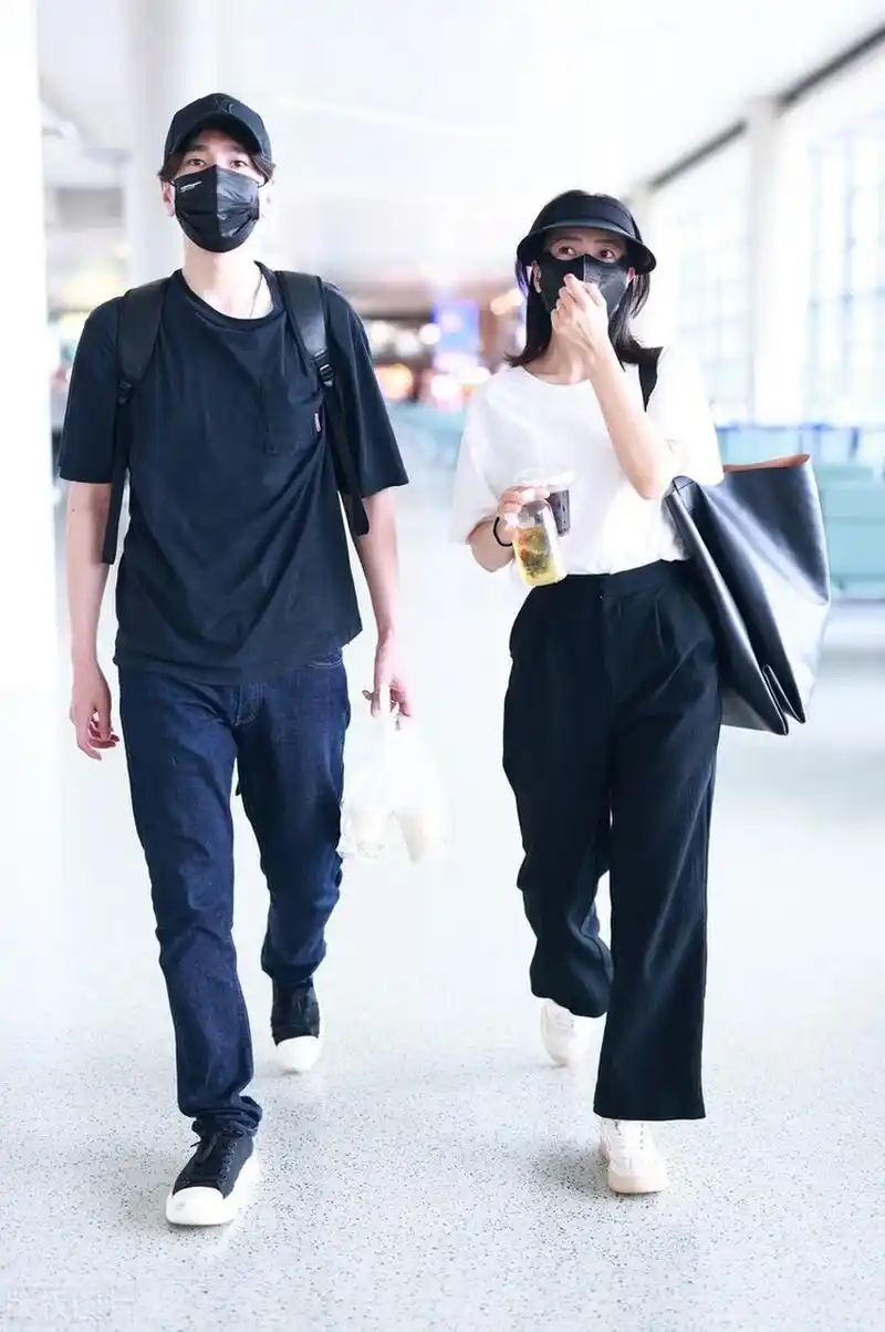 高圆圆赵又廷夫妻二人机场街拍,二人都是黑色系着装,情侣装感很强