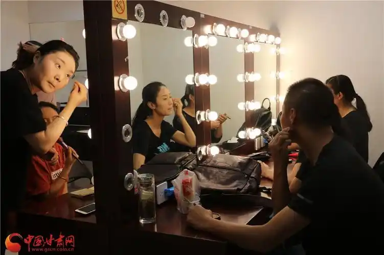 上台前,演员们在梳妆台前集体化妆打扮.