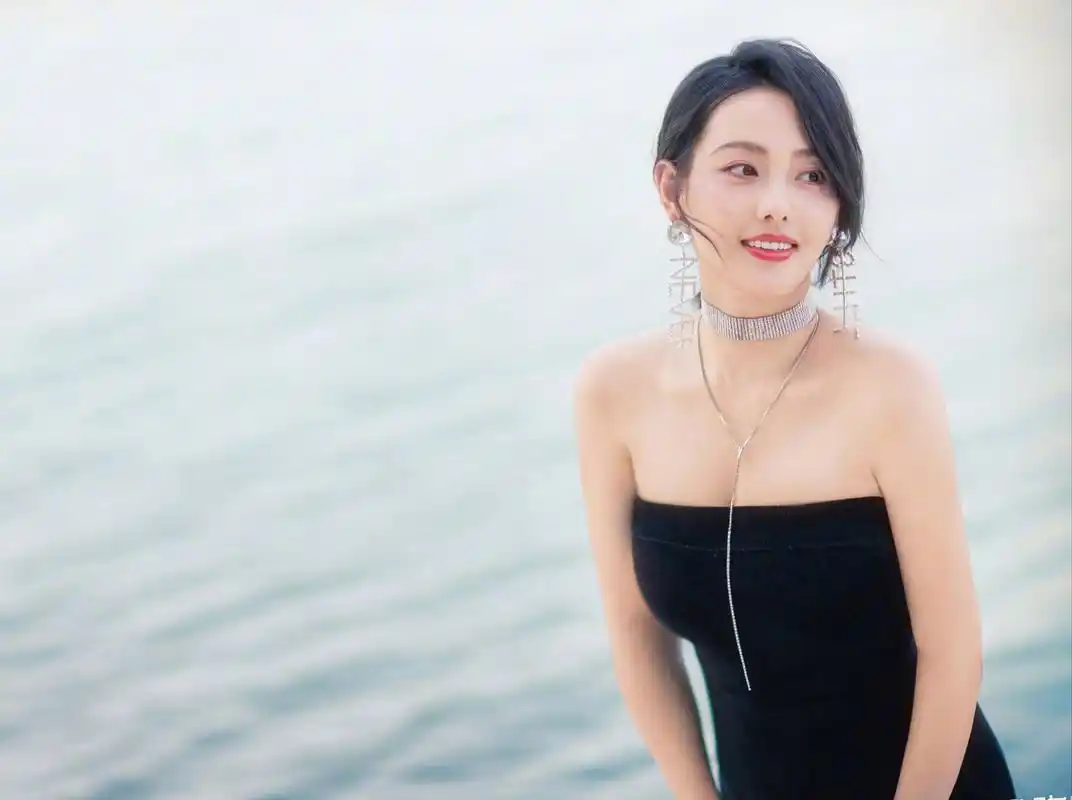 海边的女演员,身穿一件黑色抹胸裙