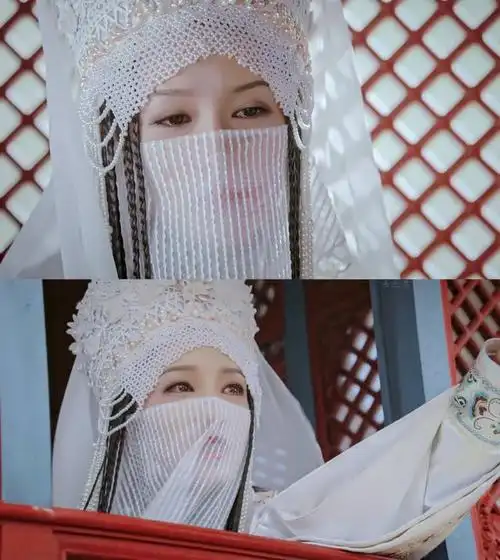 身穿一袭古装白衫,再搭配上白色头饰,戴着珍珠面纱,造型充满异域风情
