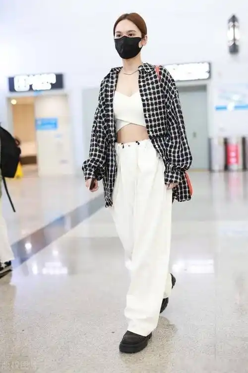 杨丞琳格纹衬衫搭白色阔腿裤亮相机场,橘色小包点亮全身_上海_杨丞琳