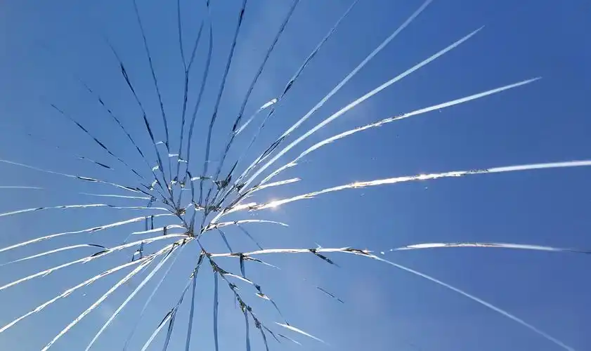 蓝天背景上有裂缝的碎玻璃