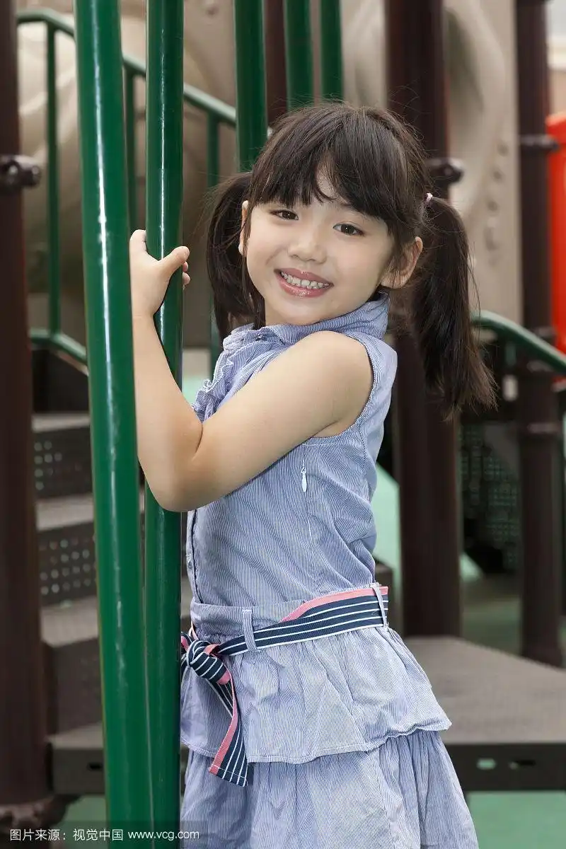 小女孩在幼儿园内玩滑梯