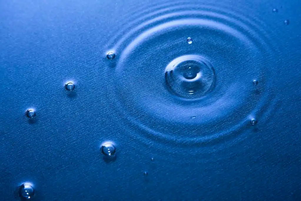 滴清澈的水,在湿地板上慢慢下落的水滴入