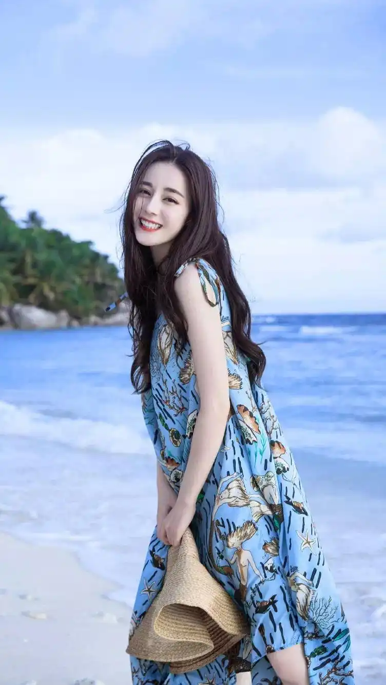 迪丽热巴蓝色碎花裙现身海边,笑容甜美,宛如夏日精灵