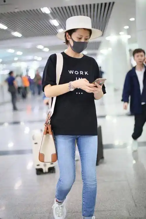 47岁洪欣低调走机场,黑t恤搭配牛仔裤简约清爽,素颜难掩好气质