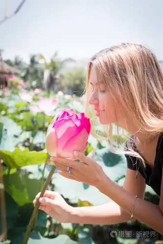 这朵美丽的睡莲或莲花.女孩握在她的手一朵花和微笑