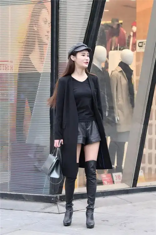 黑色细高跟过膝长靴,修身款式,搭配黑色风衣,时尚抢眼